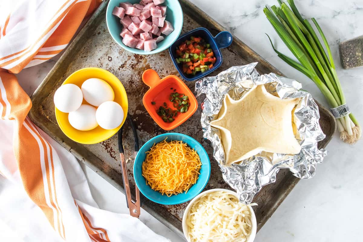 ingredients for a breakfast bowl on a baking sheet.