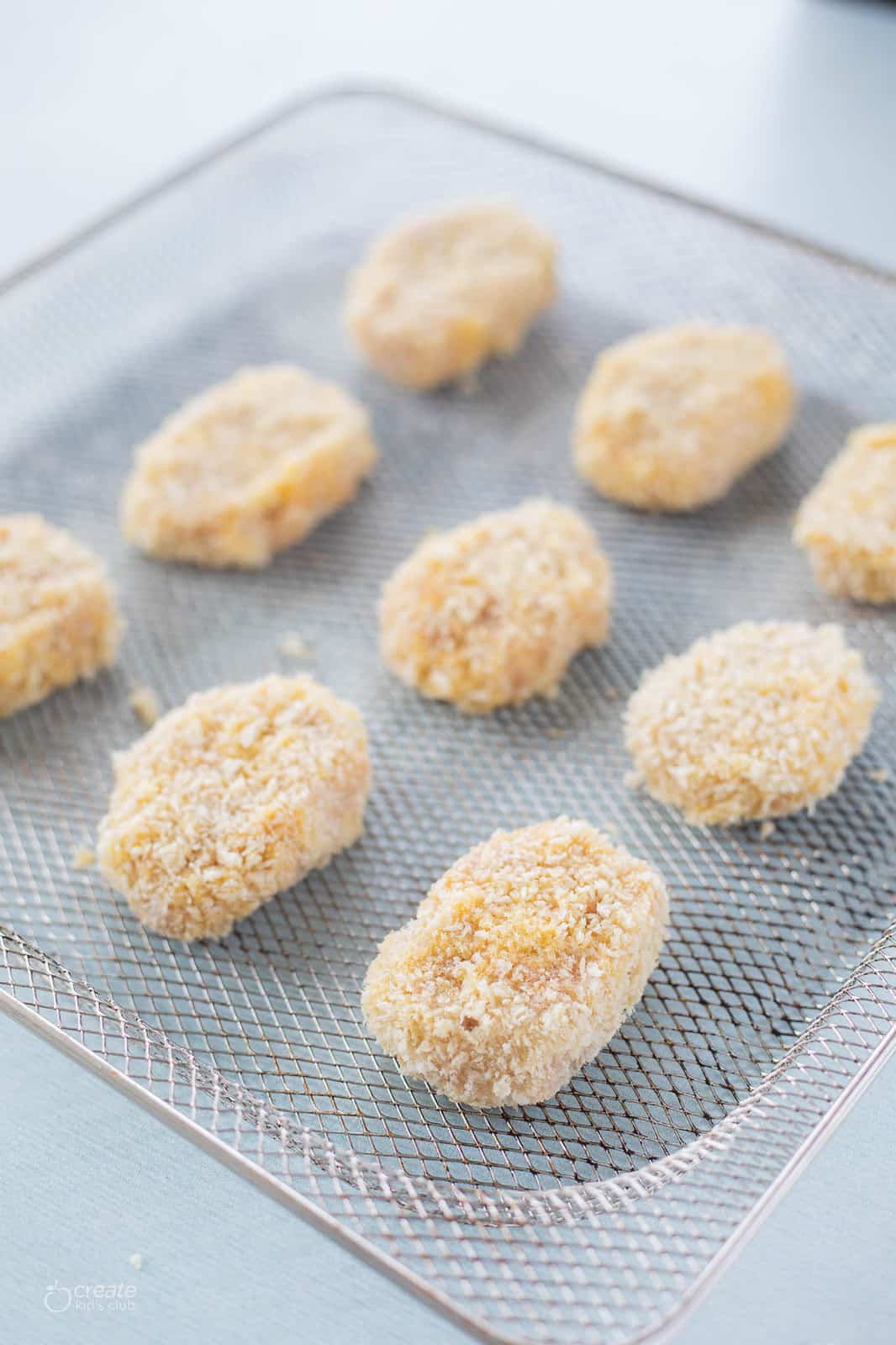 uncooked chicken nuggets on an air fryer tray