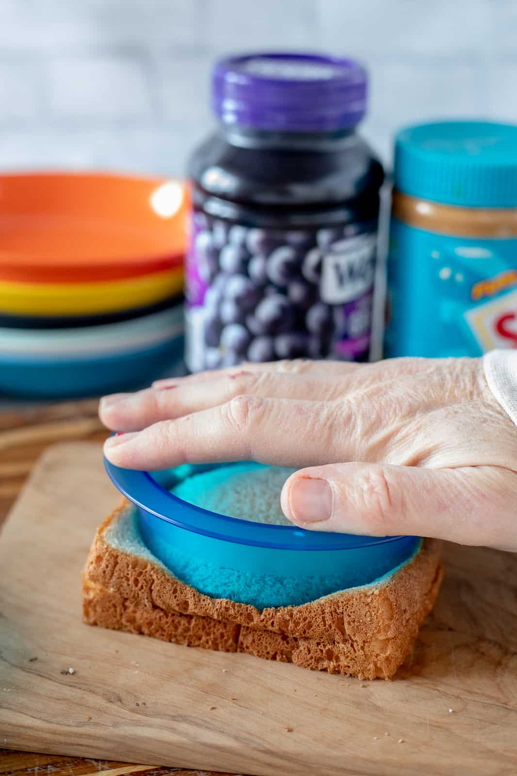 hand pressing an uncrustable cutter onto bread