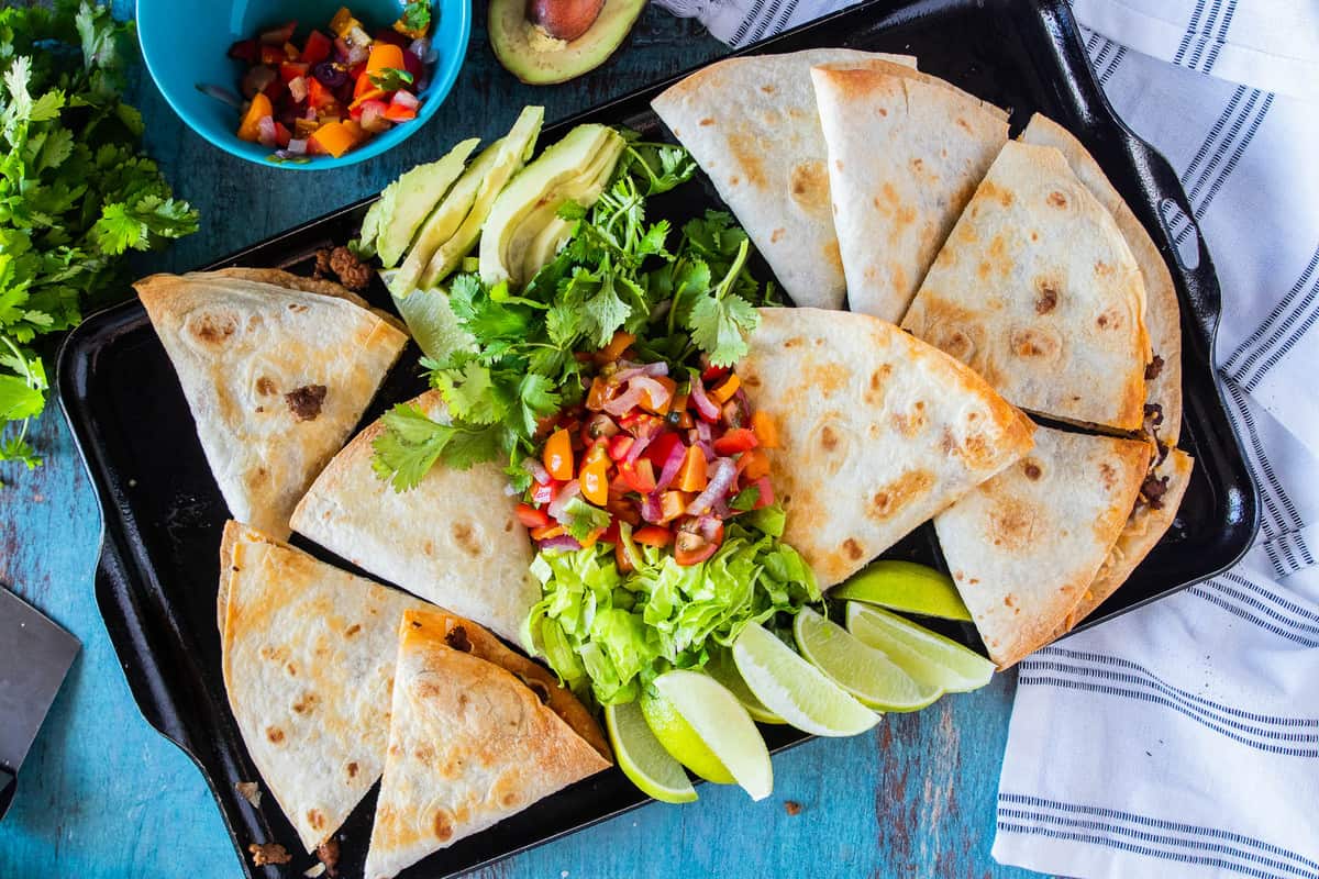 quesadillas on a tray with taco toppings