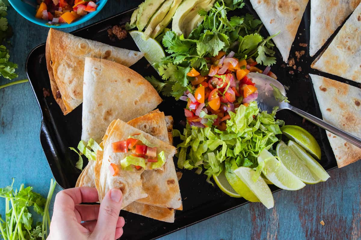 quesadilla on serving tray with toppings