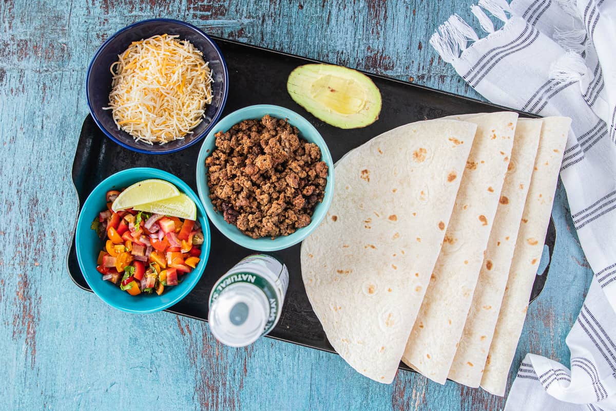 ingredients for taco quesadillas on a tray