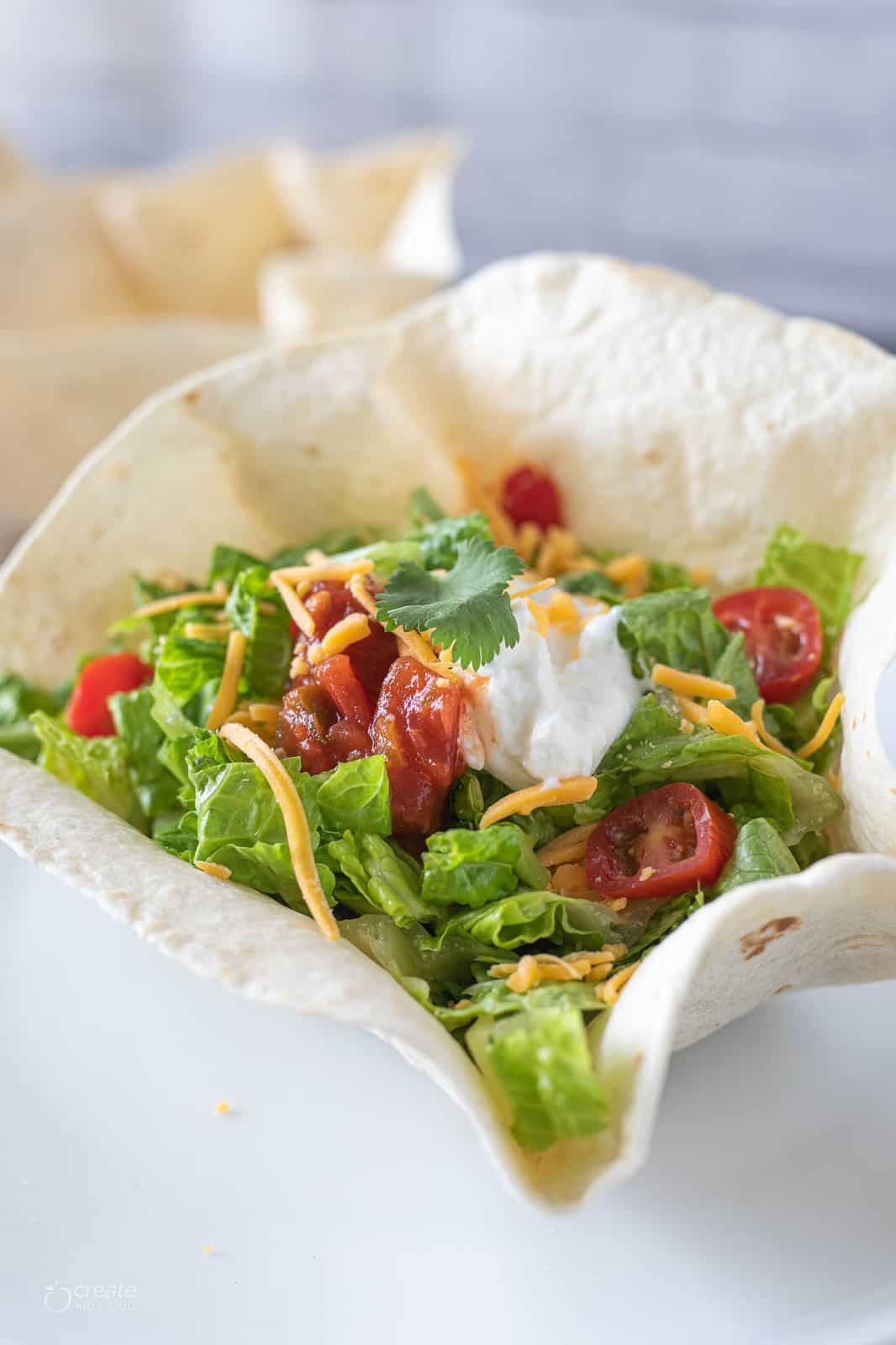 taco shell bowl filled with taco meat and toppings