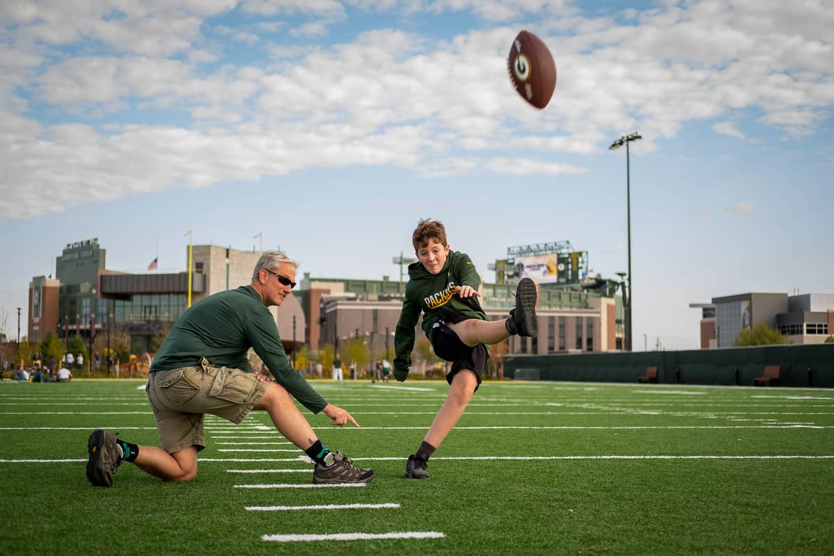 father and son playing football at Lambeau Field