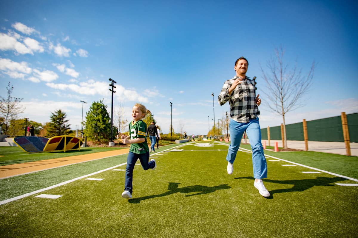 Family running on a football field