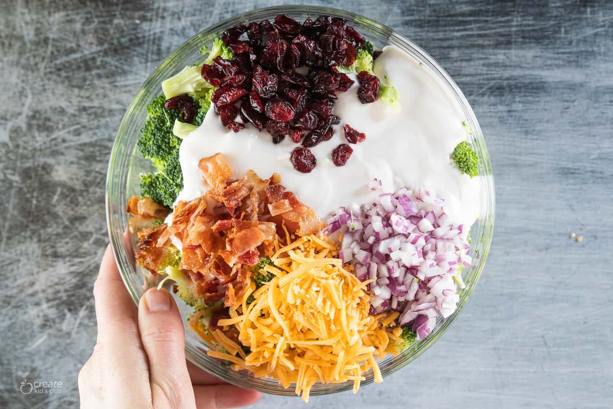 salad ingredients with dressing in a mixing bowl