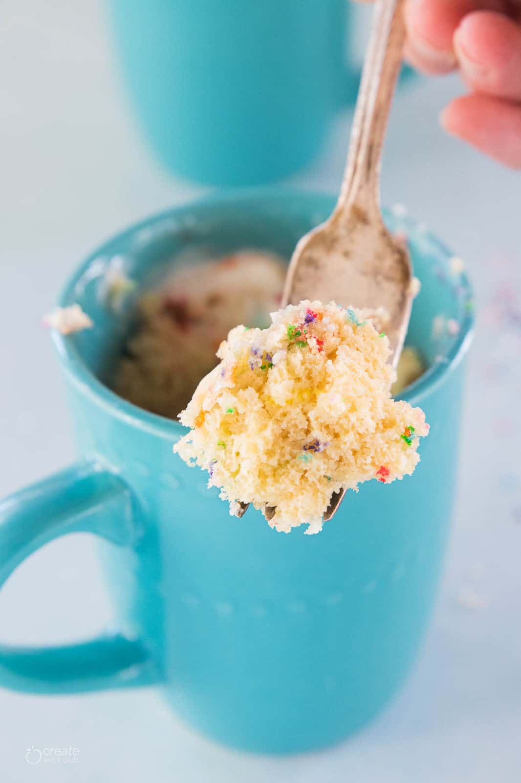 vanilla cake scooped from mug with a fork