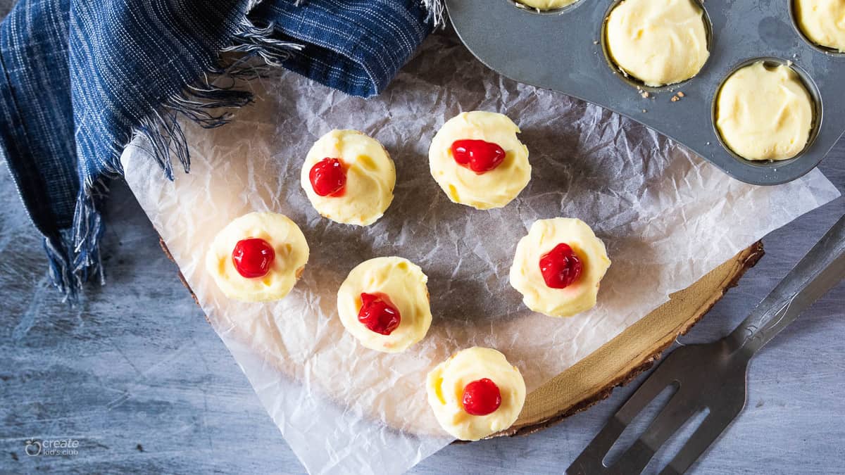 Frozen cheesecake bites on a piece of parchment paper. 