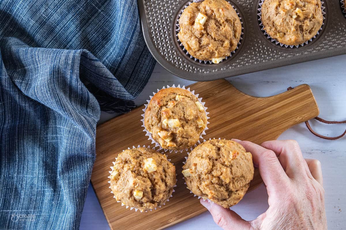 hand grabbing an apple muffin