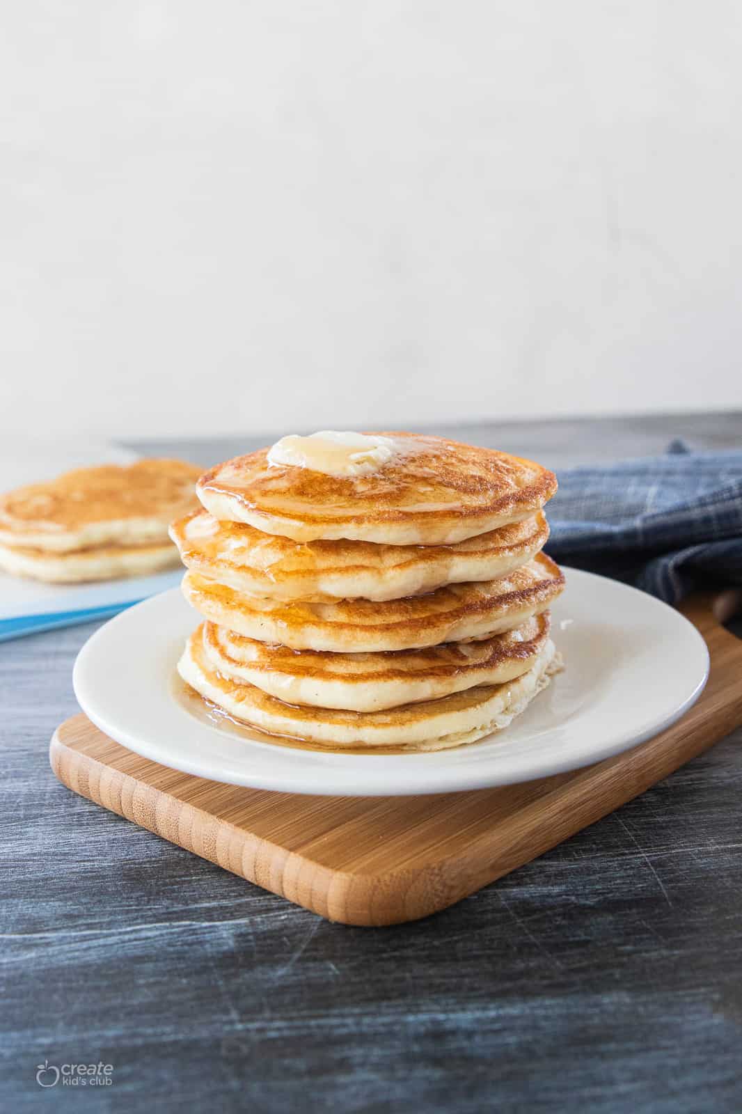 stack of pancakes on a plate with butter and syrup