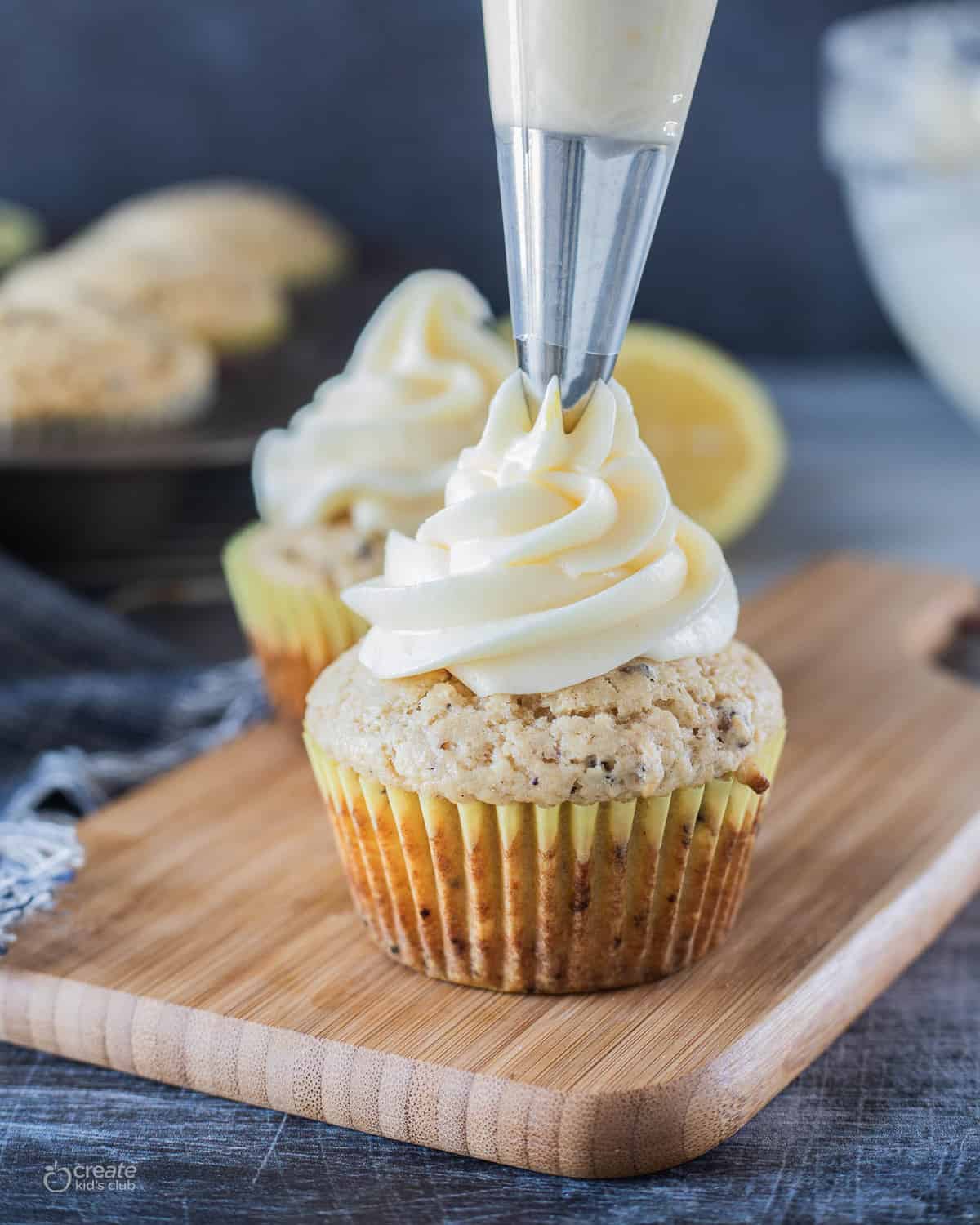 lemon cream cheese icing piped on top of a cupcake