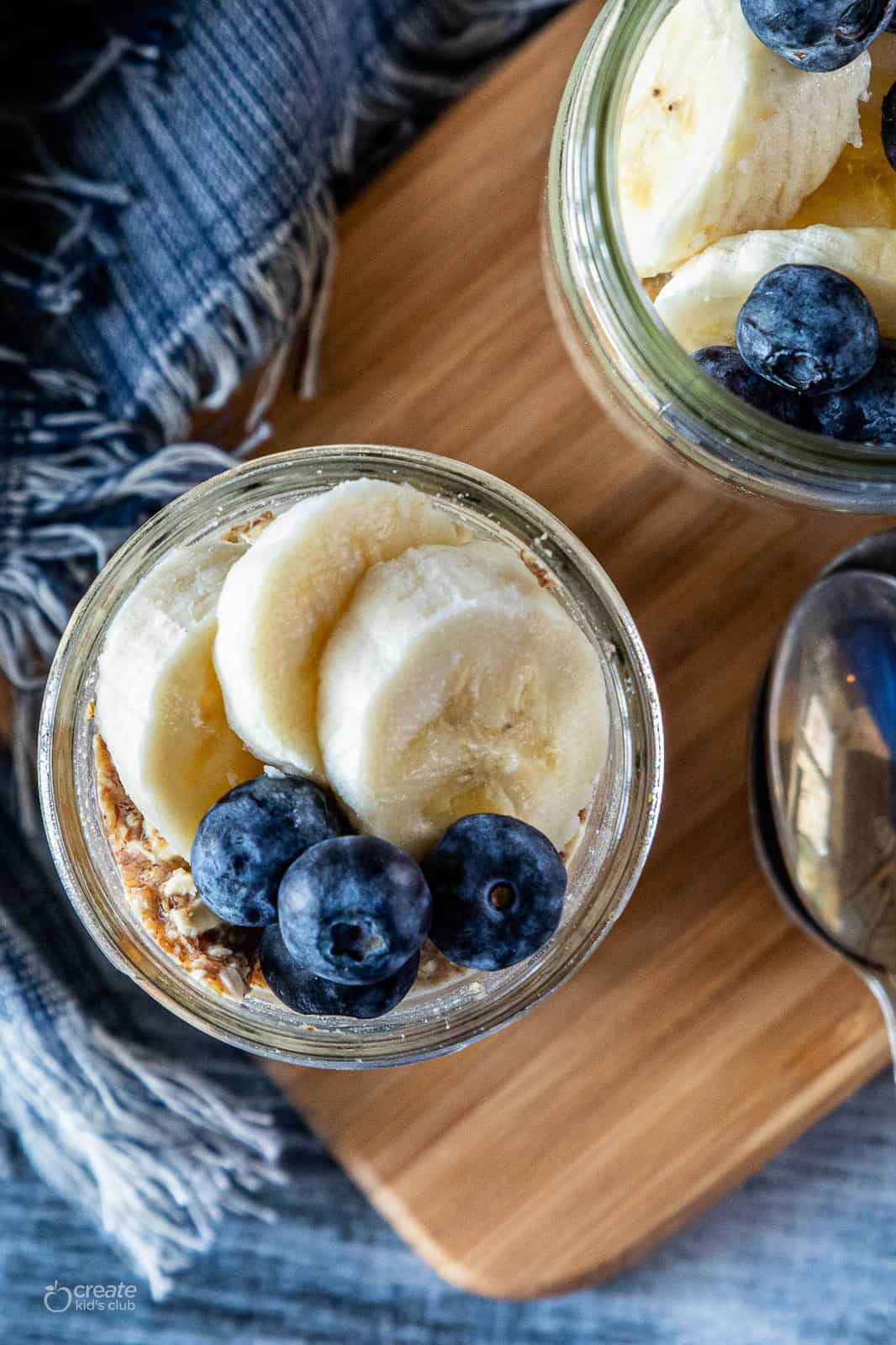 mason jar filled with peanut butter overnight oats, banana and blueberries