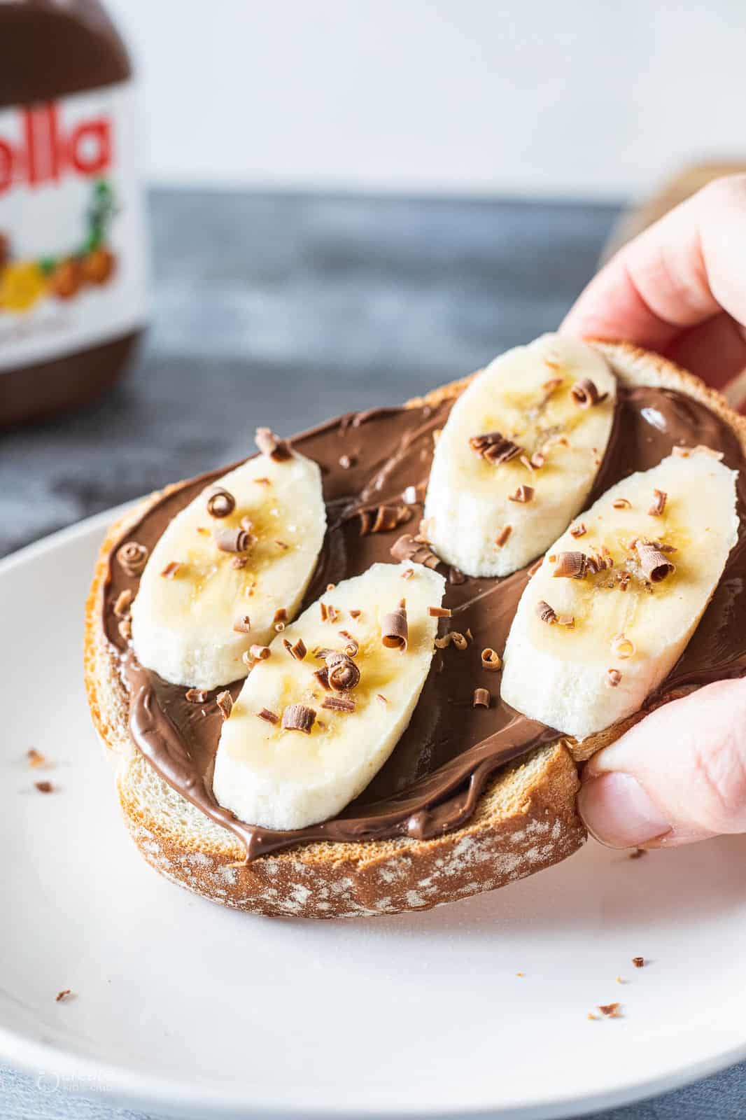 Nutella, banana slices and shredded chocolate on toast. 