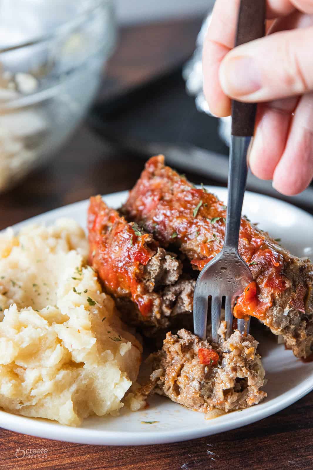 meatloaf on plate with mashed potatoes with a fork