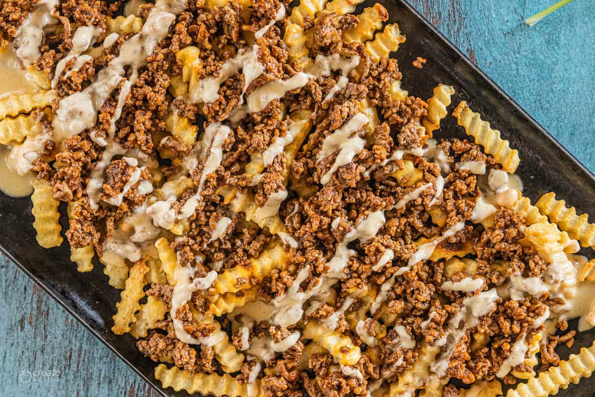 fries with meat and cheese sauce on a baking dish. 