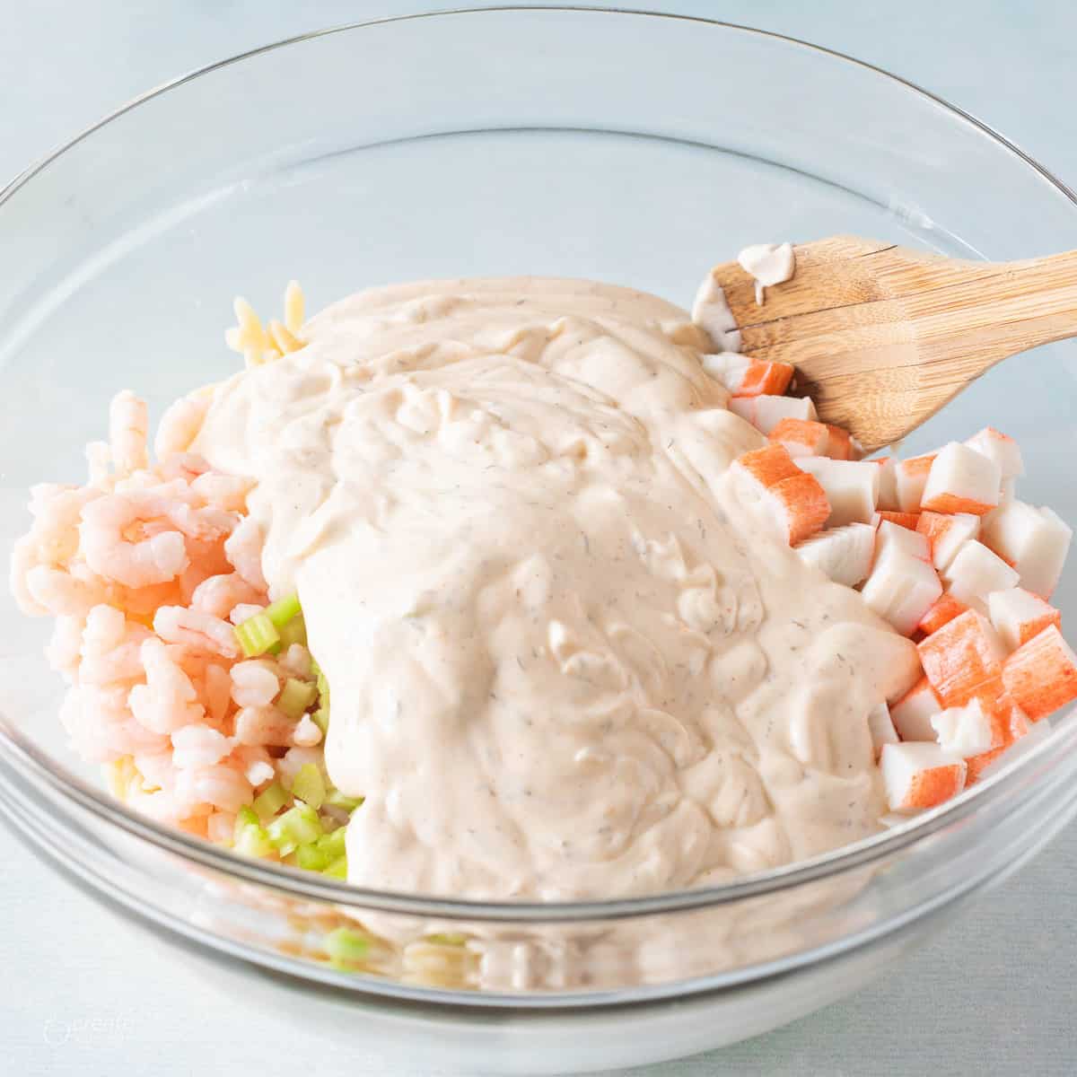 seafood ad creamy style dressing in bowl with wooden spoon