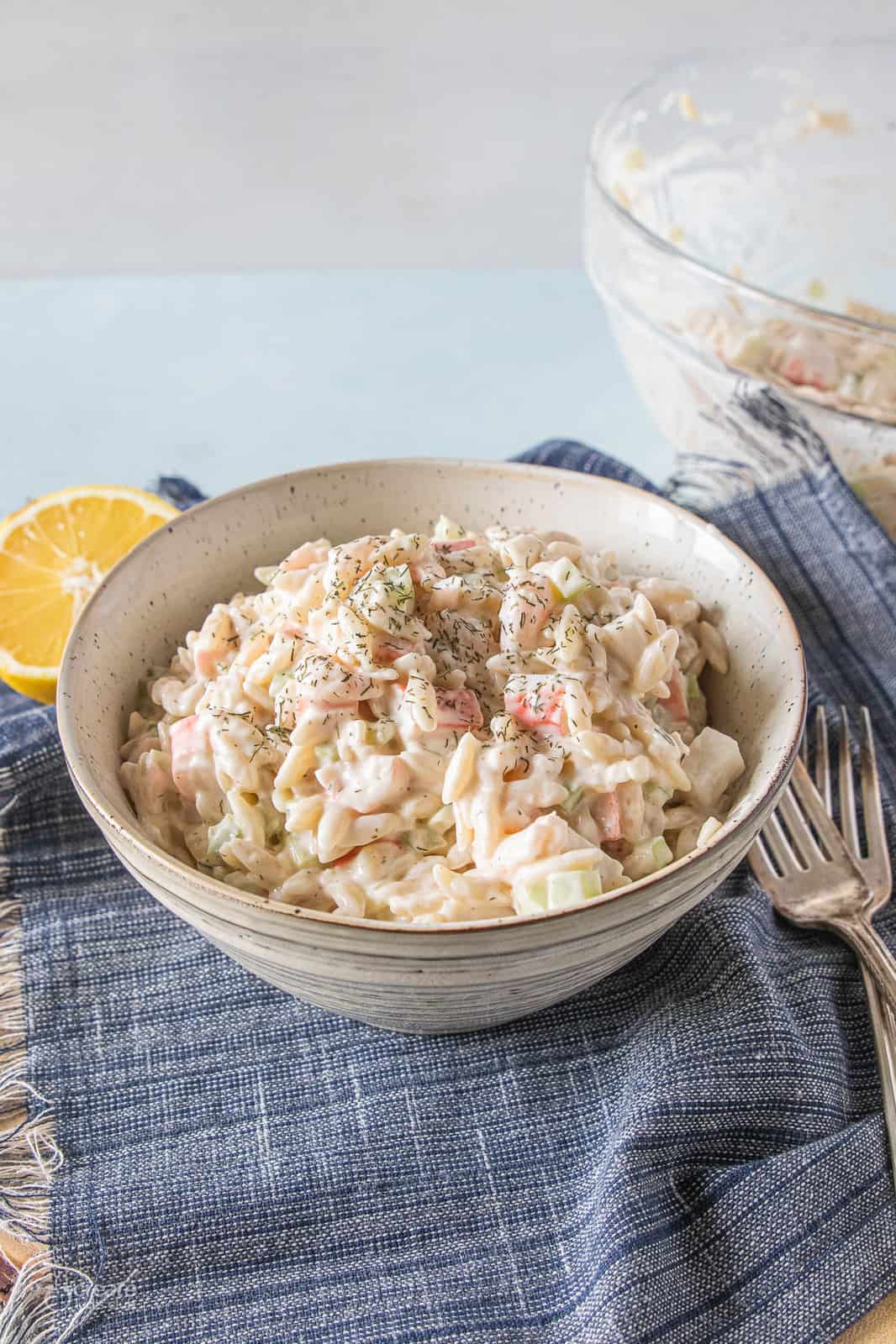 Seafood salad with orzo pasta in a bowl.