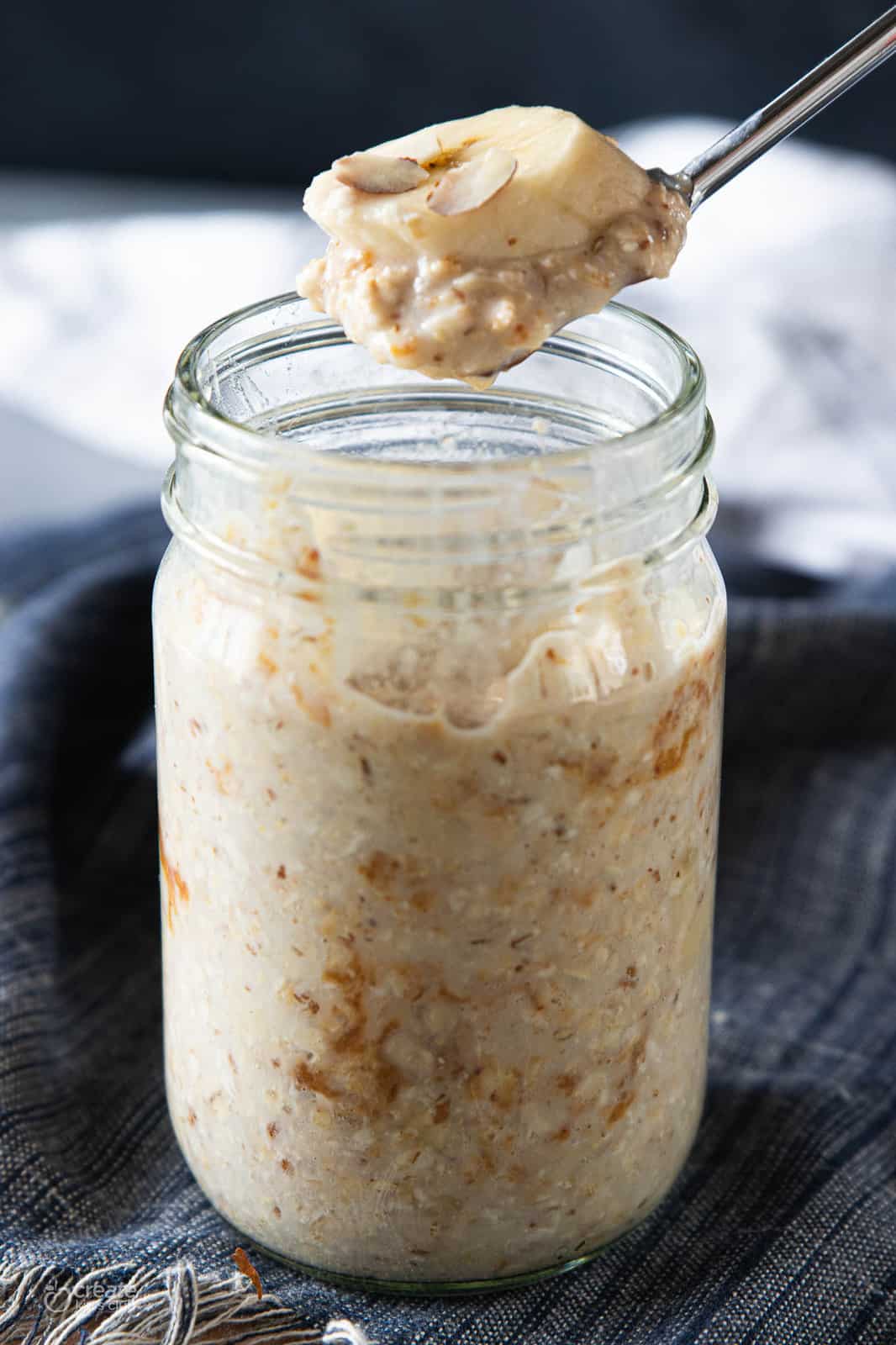spoon scooping a bite of oatmeal from mashed jar