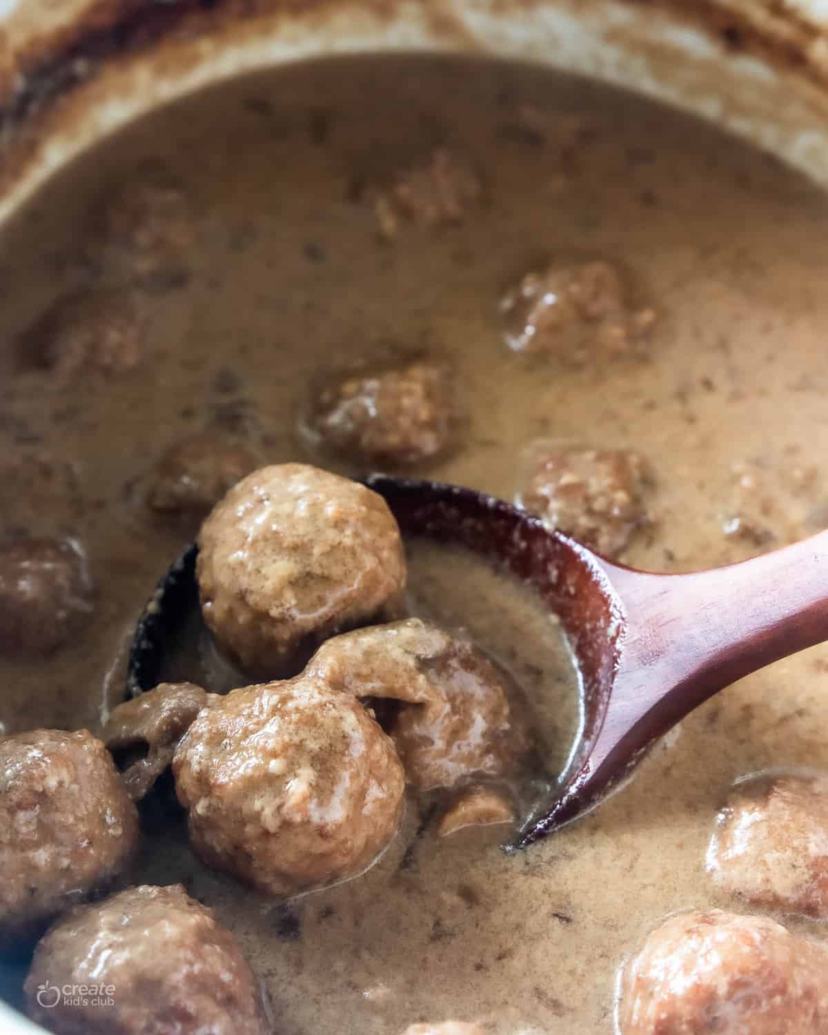 spoon ladling swedish meatballs from crockpot