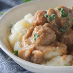swedish meatballs on top of mashed potatoes in a bowl