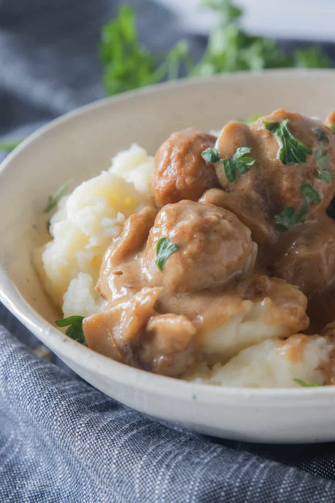 swedish meatballs on top of mashed potatoes in a bowl