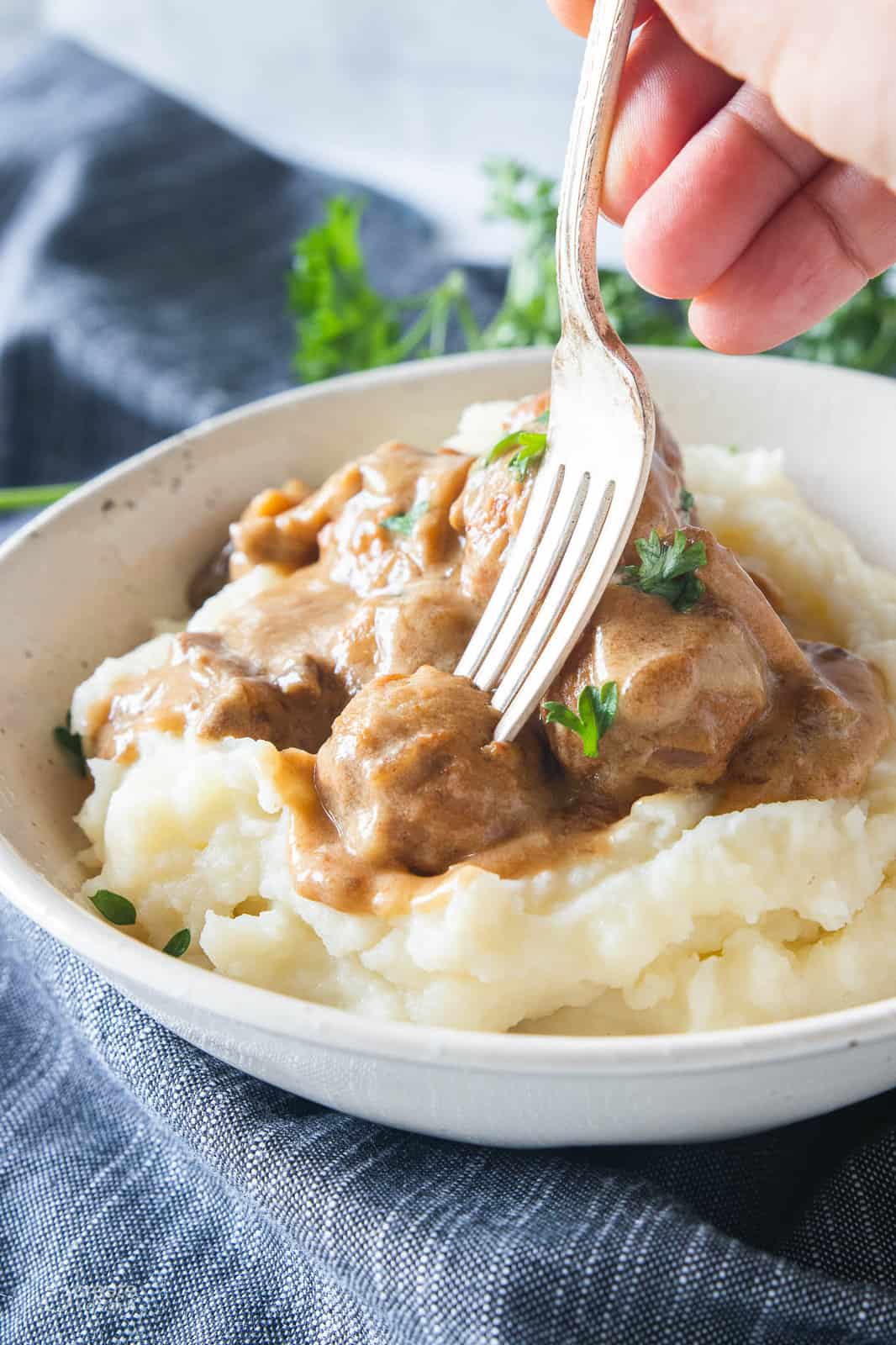 swedish meatballs on top of mashed potatoes in a bowl