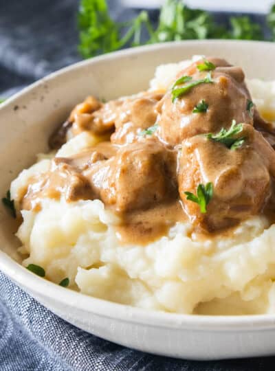 swedish meatballs on top of mashed potatoes in a bowl