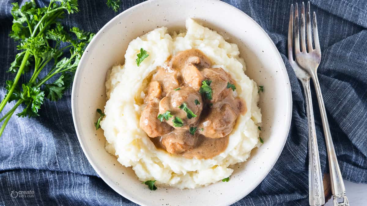 swedish meatballs on top of mashed potatoes in a bowl