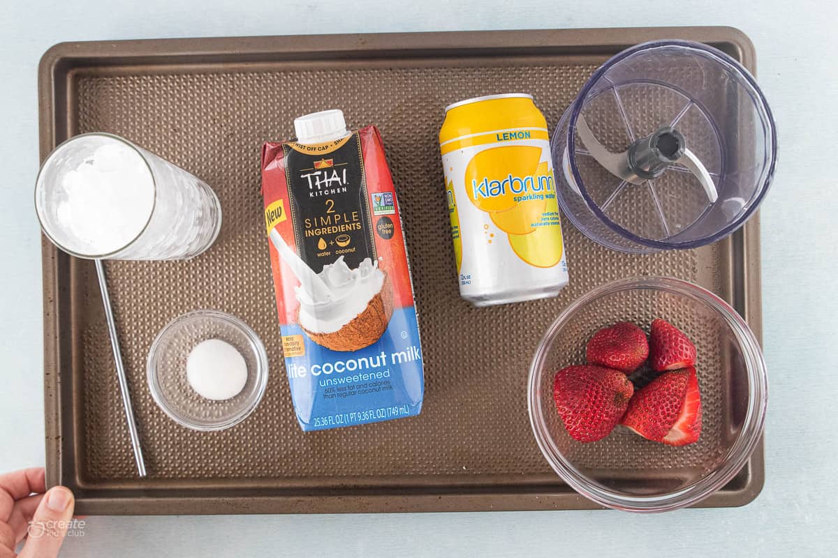 Ingredients to make a pink drink with strawberries.