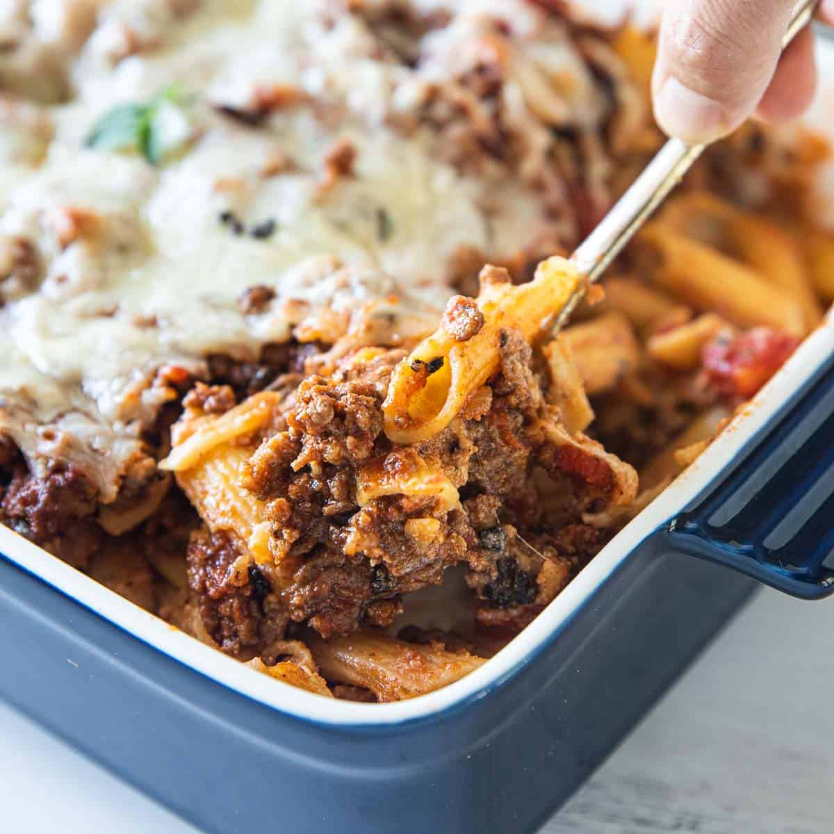 spoon scooping baked ziti with sausage