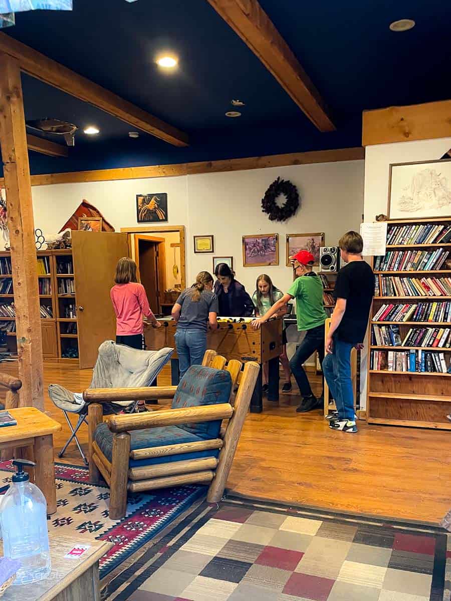 Teens playing foosball in a rec center at Sundance Trail guest ranch.