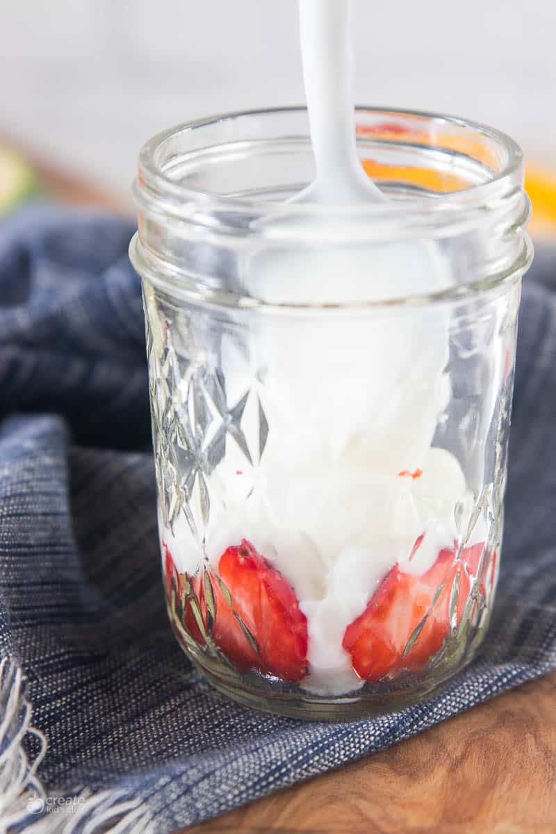 strawberries and yogurt in bottom of mason jar
