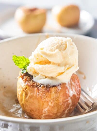 baked apple topped with scoop of vanilla ice cream