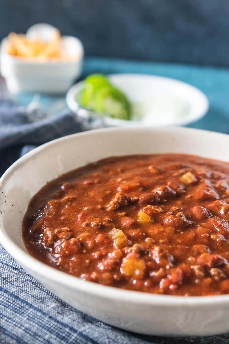 A close up of a bowl of slow cooker chili with beans and ground beef.