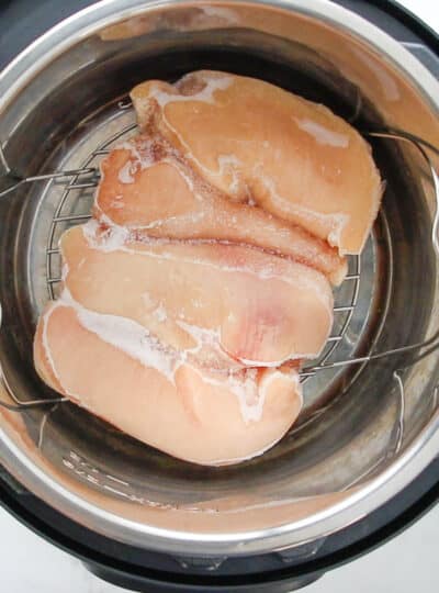 Frozen chicken breast in an instant pot on a wire rack.
