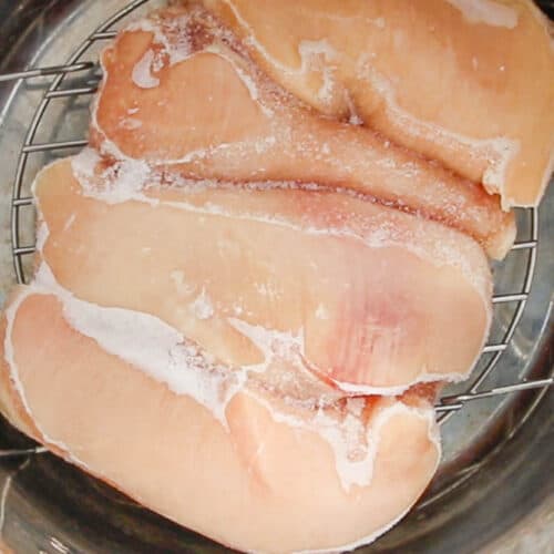 Top down view of frozen chicken breasts in an instant pot.