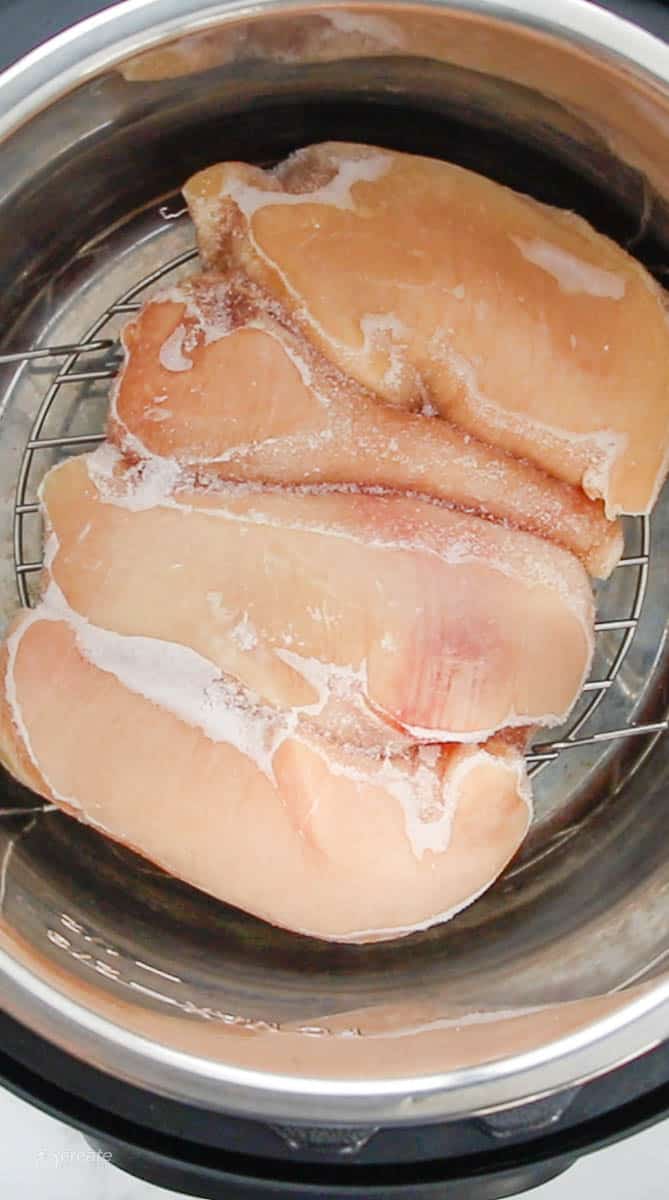 Top down view of frozen chicken breasts in an instant pot.
