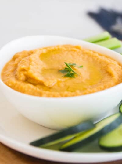 homemade hummus in bowl next to fresh vegetables