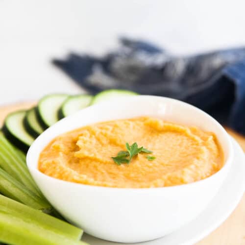 homemade hummus in bowl next to fresh vegetables