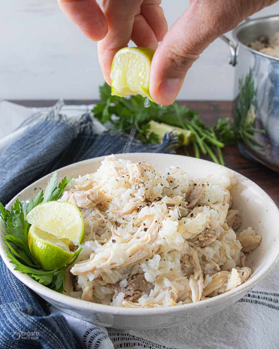 lime squeezed on boiled chicken and rice in serving bowl