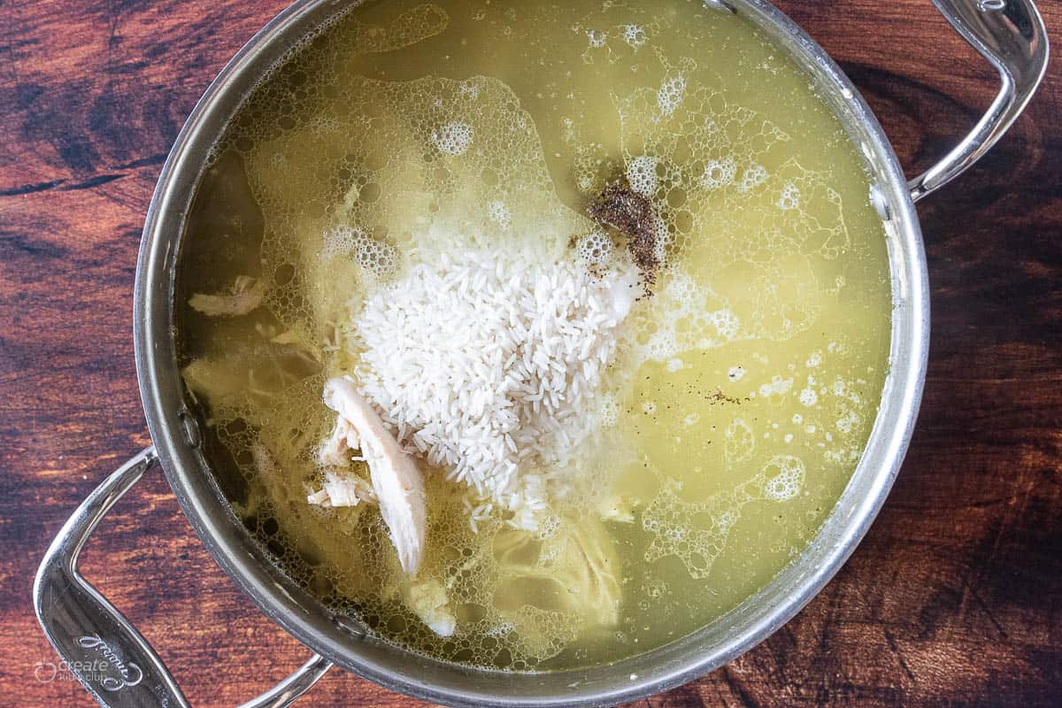 chicken and rice boiling in pan