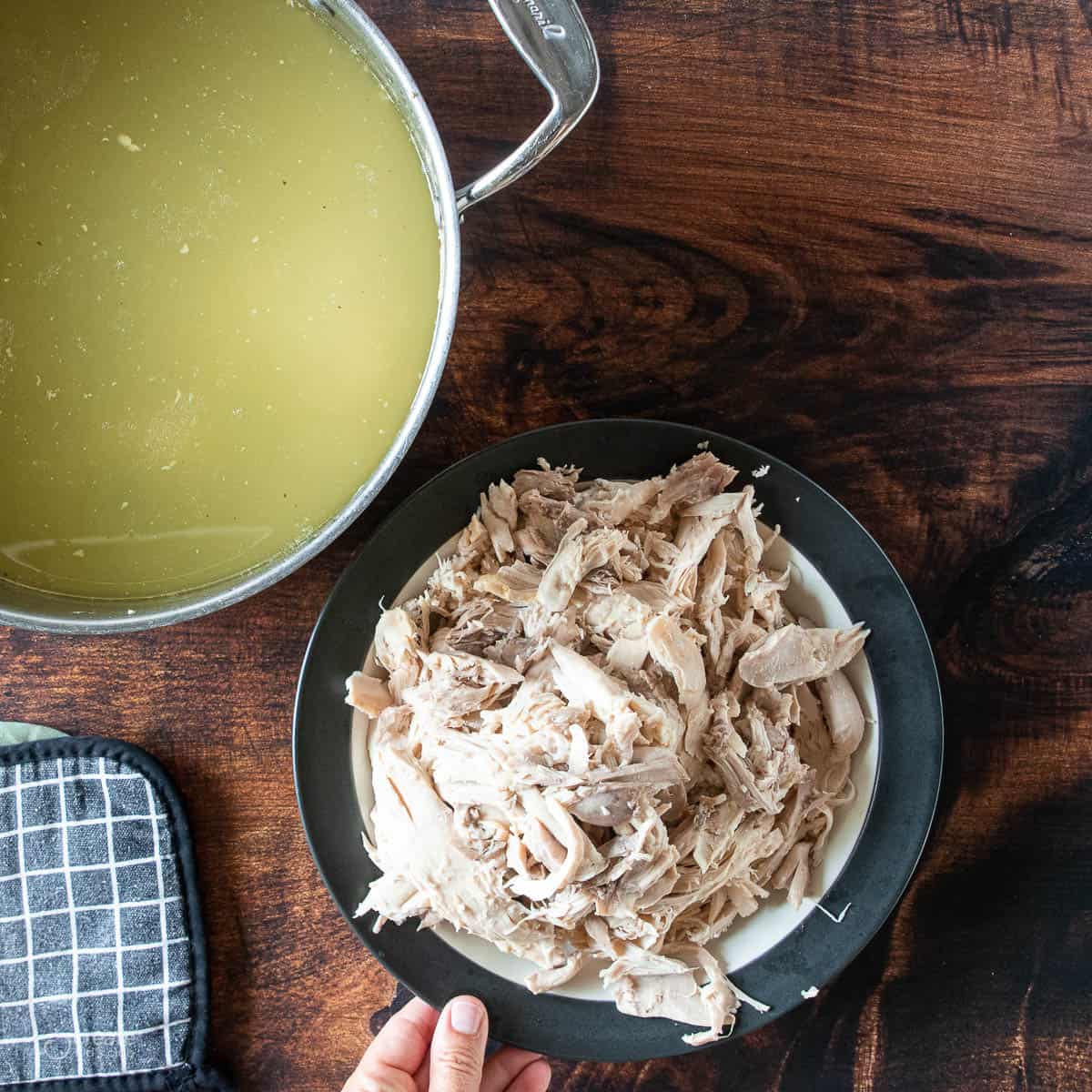 boiled chicken in bowl next to chicken stock