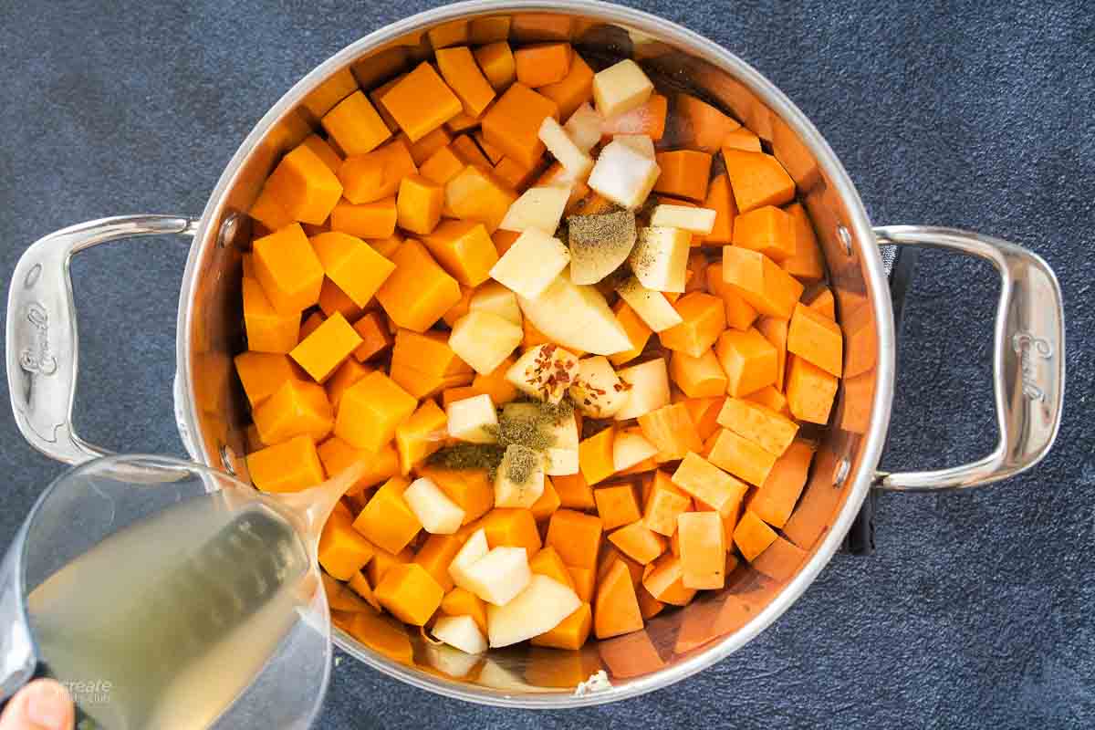 broth poured over chopped butternut squash in stock pot