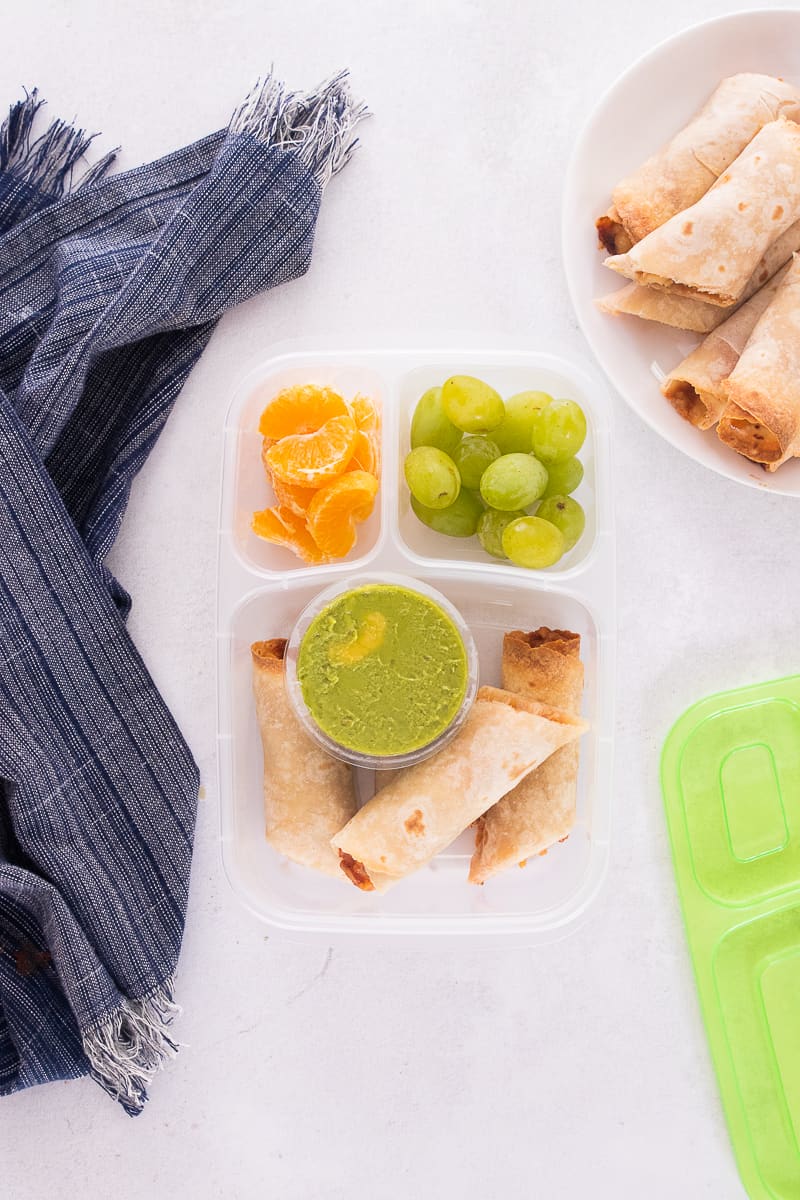 taquitos packed with guacamole in a lunch container.