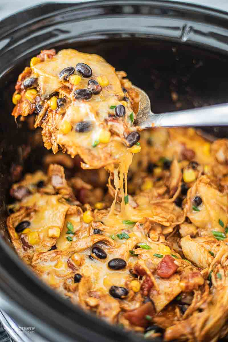 spoon serving chicken enchilada from crockpot