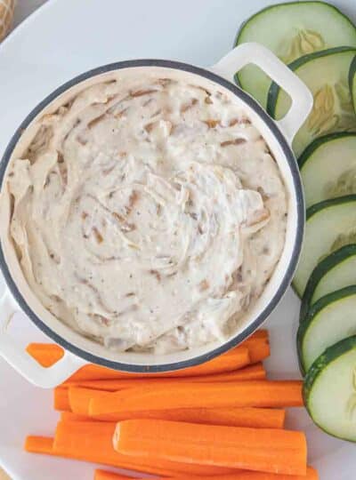 close up view of sweet onion dip in bowl next to vegetables