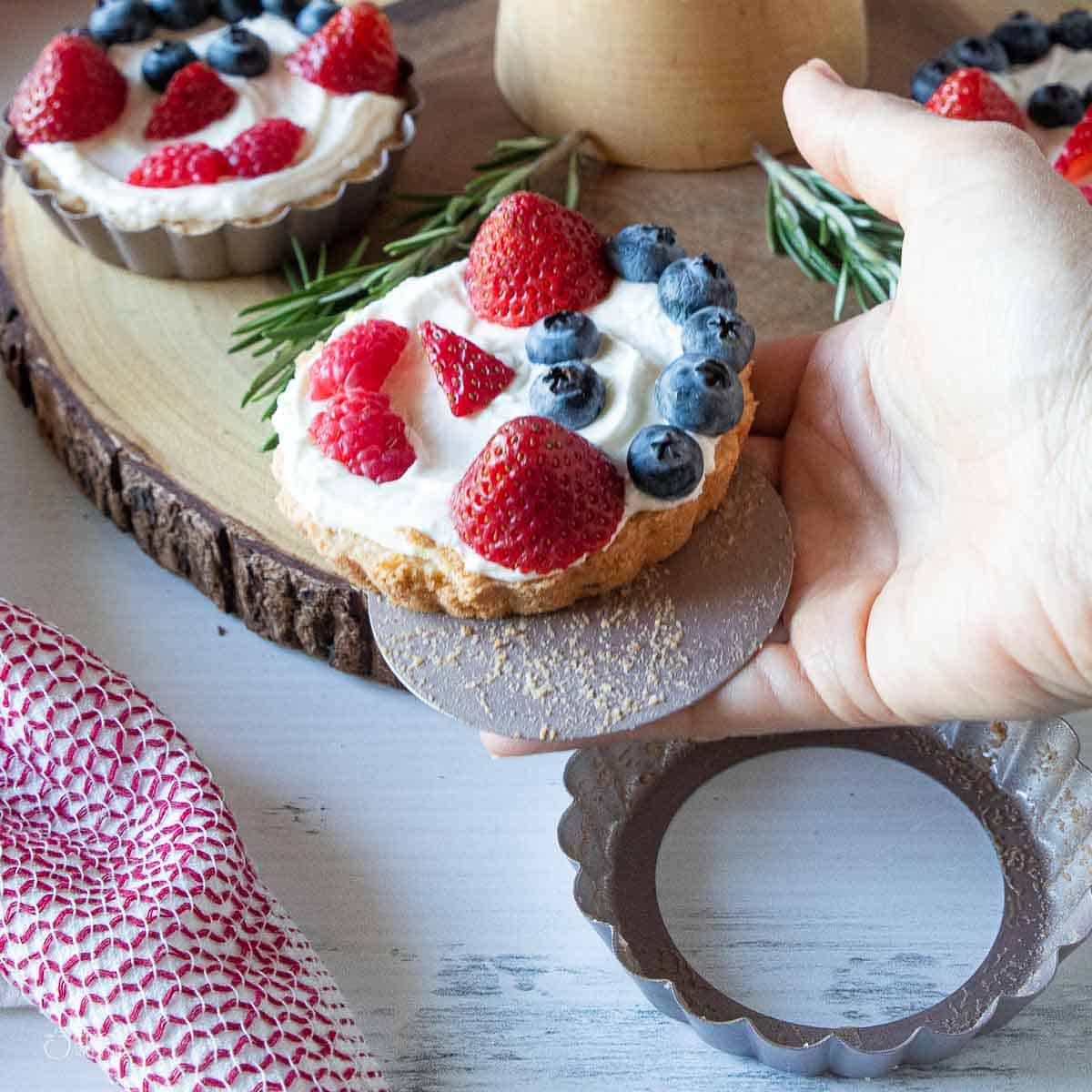 fruit tart being removed from tart mold