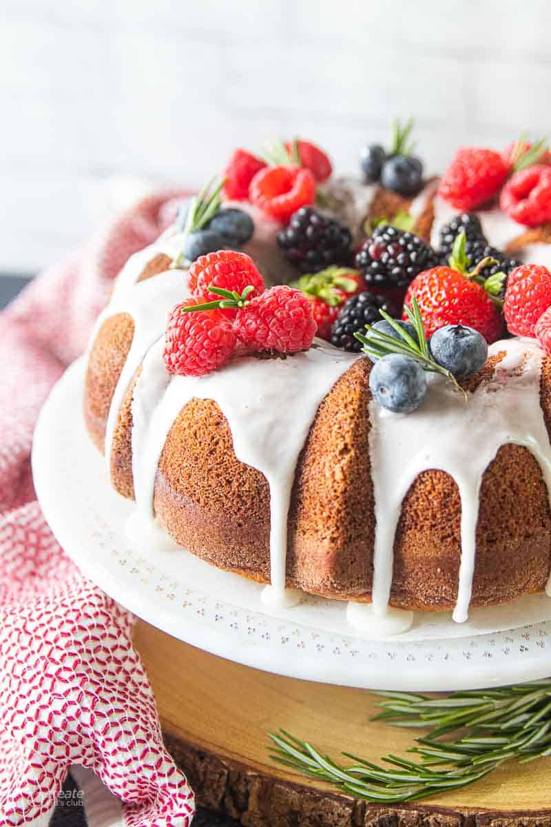 Bundt cake topped with berries on a serving dish