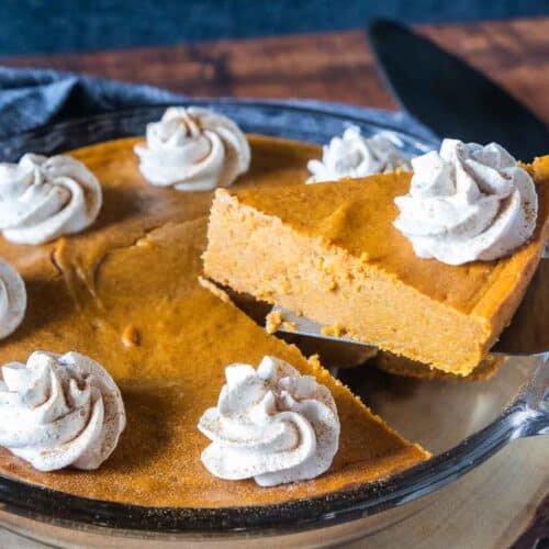 slice of pumpkin pie being removed from pie pan