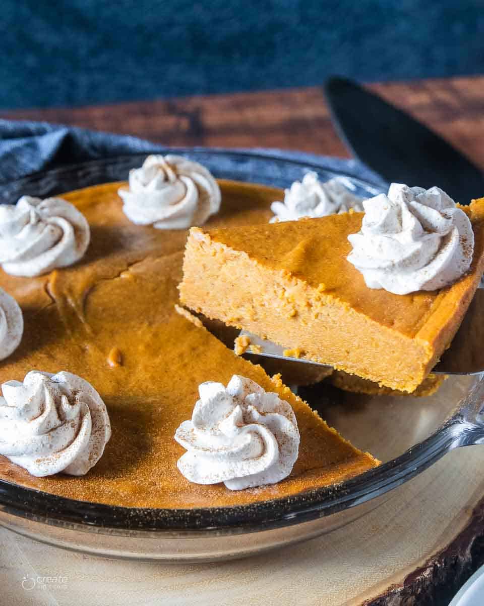 slice of pumpkin pie being removed from pie pan